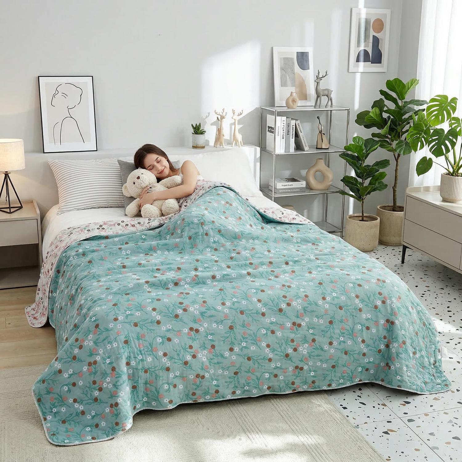 Woman sleeping soundly under a soft, reversible muslin cotton quilt with a teal floral pattern.