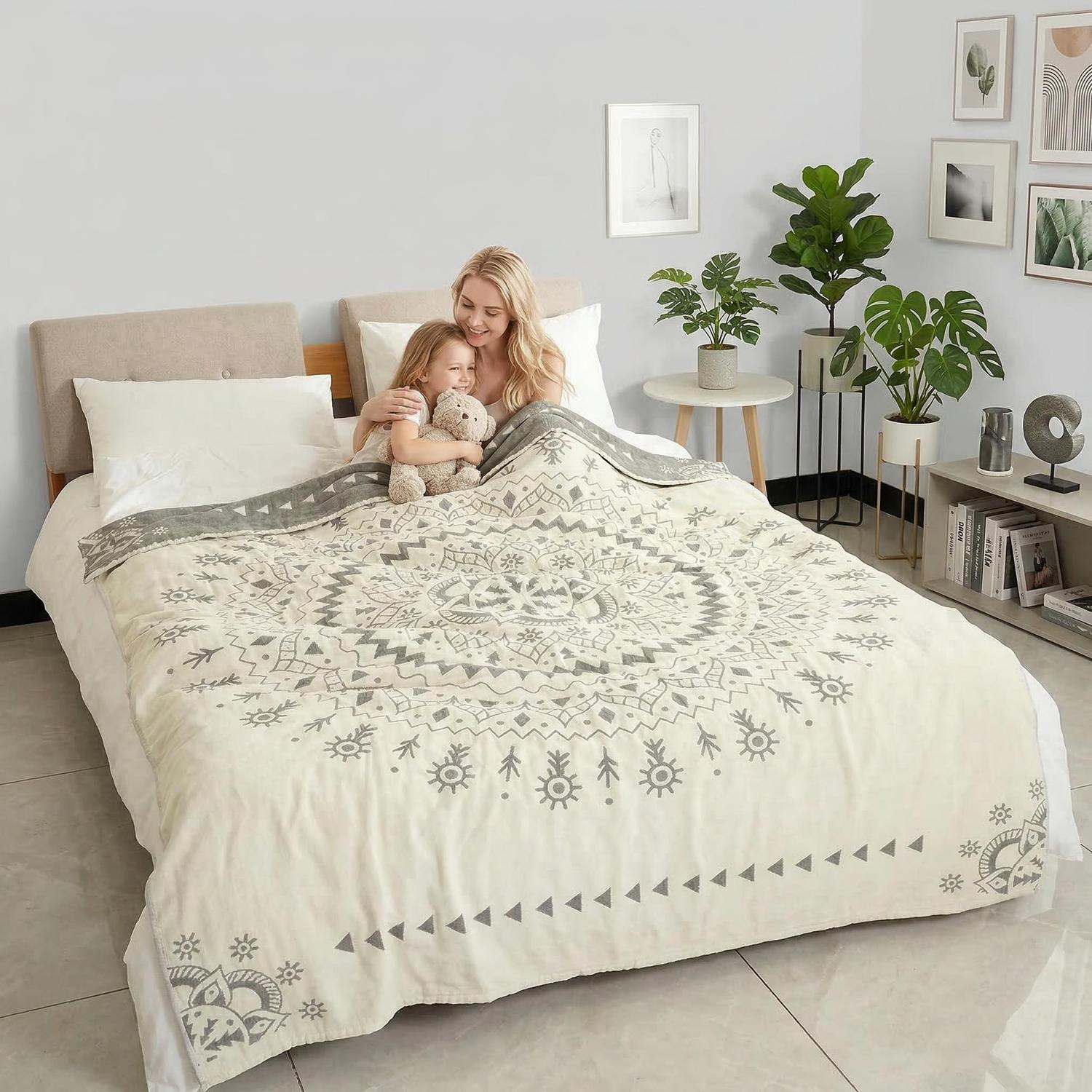 Cream soft cotton bedspread with a large gray geometric mandala pattern, covering a bed where a woman and child cuddle.