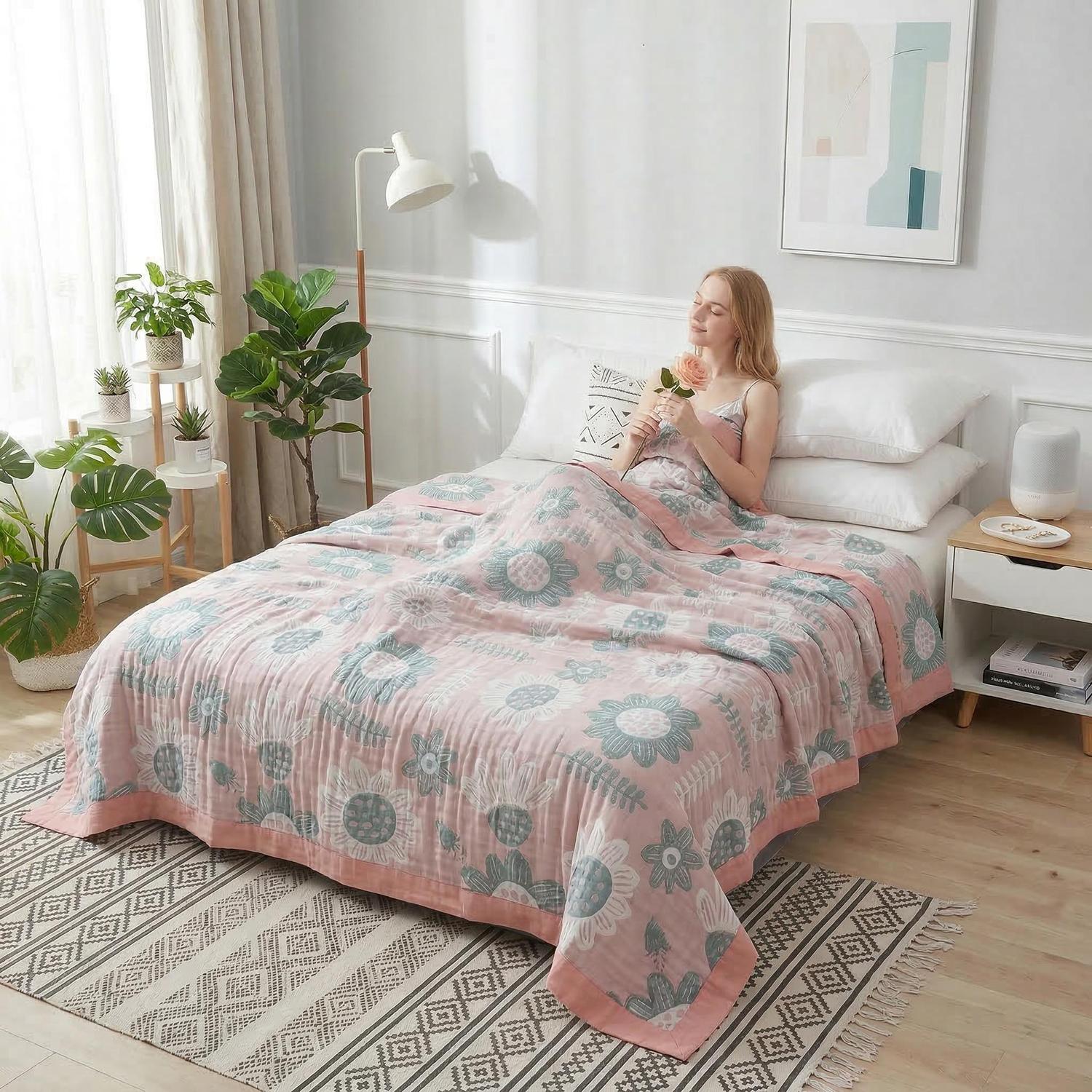 Woman relaxing in bed with a pink and blue floral soft cotton bedspread summer quilt blanket.
