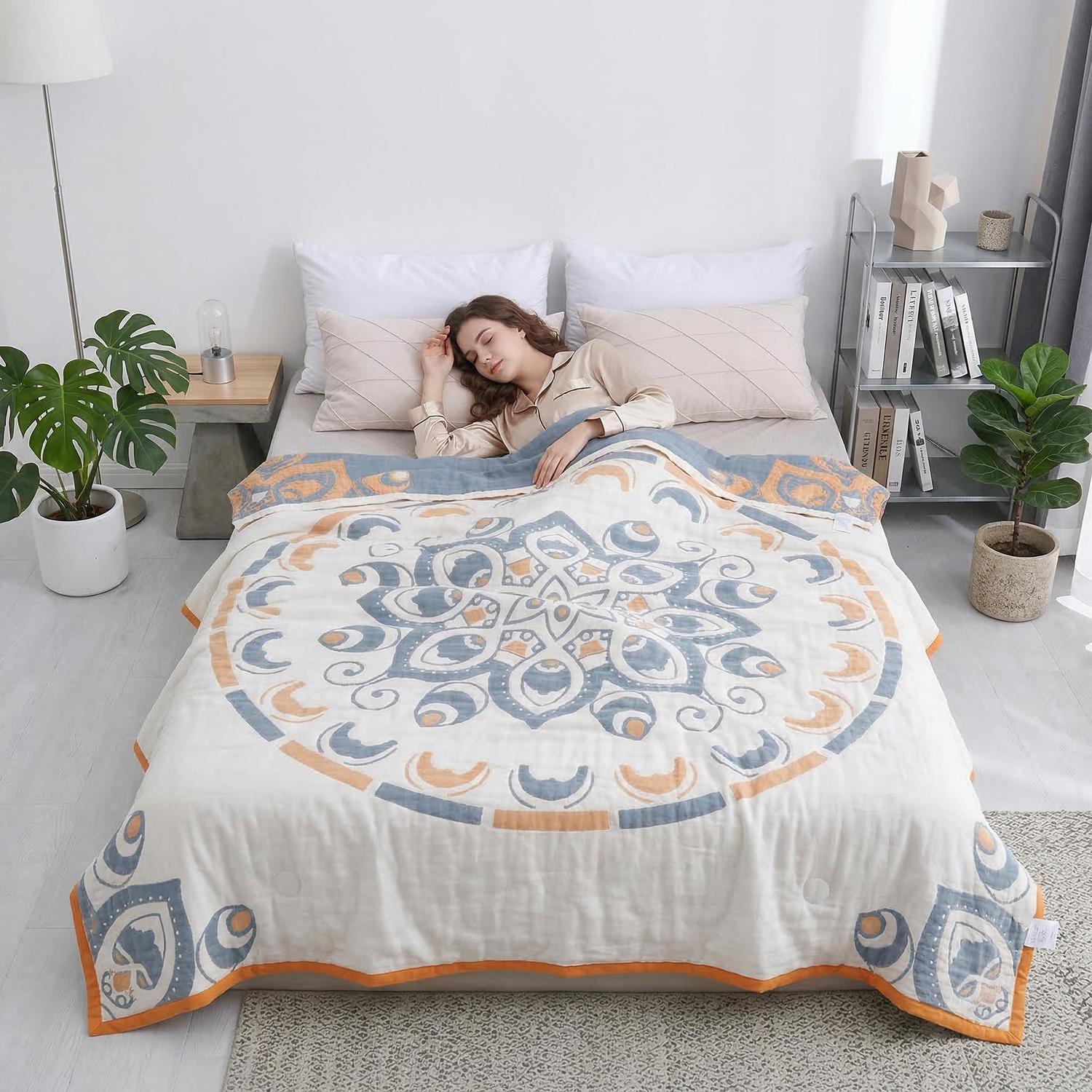 Woman sleeping under a soft cotton bedspread with a blue and orange mandala design.