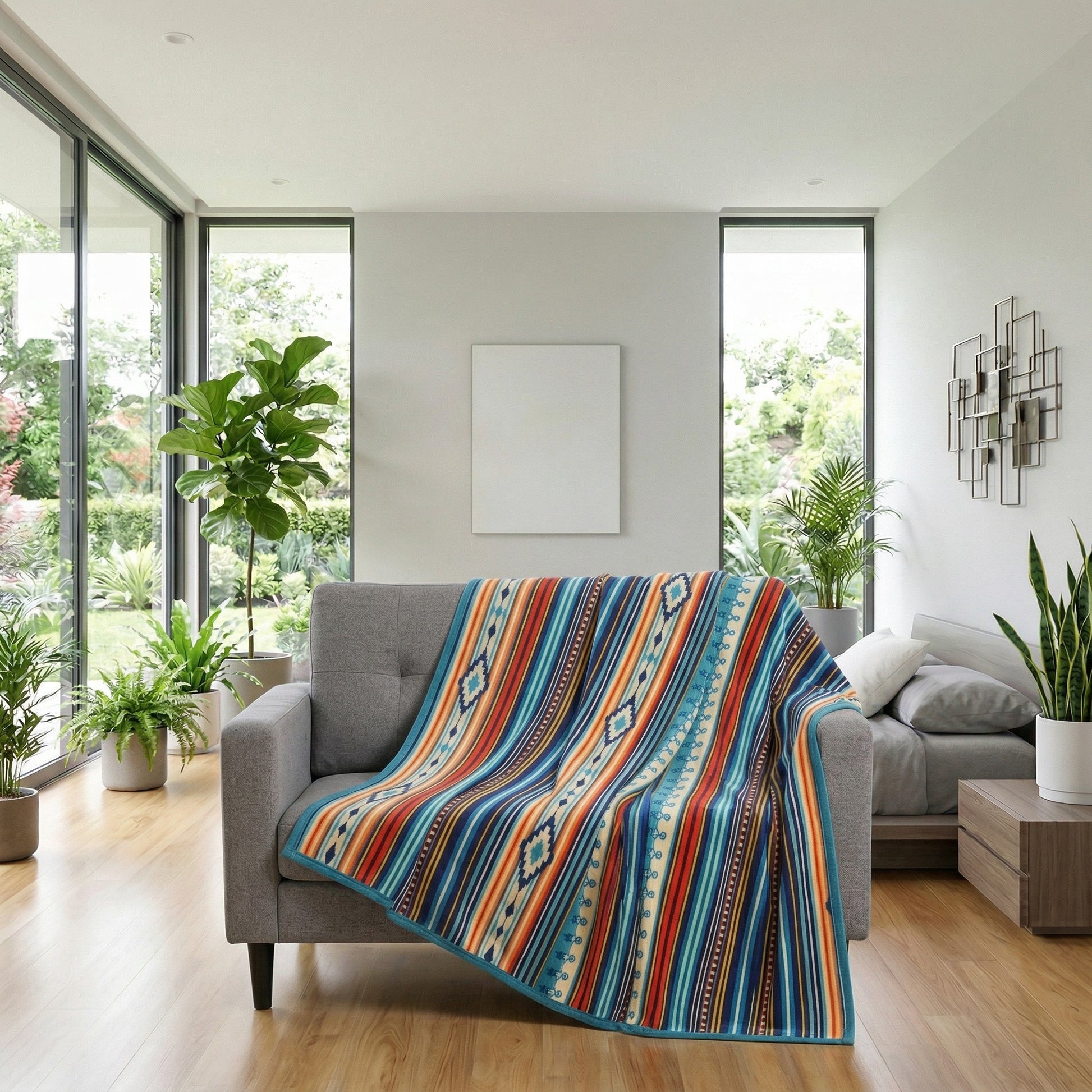 Boho throw blanket with colorful striped patterns draped over a gray sofa in a bright living room.