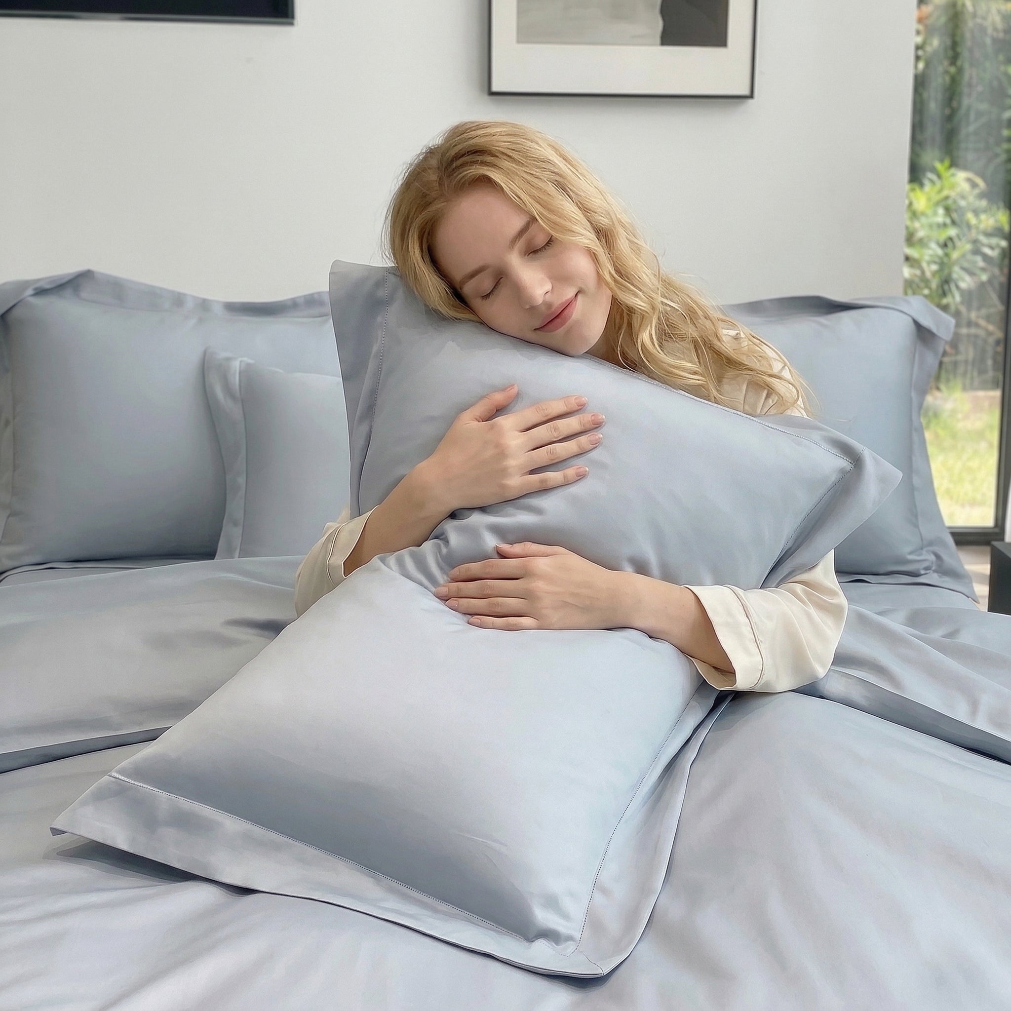 Blonde woman sleeping peacefully on a soft, light blue solid color cotton duvet cover and pillowcase set.