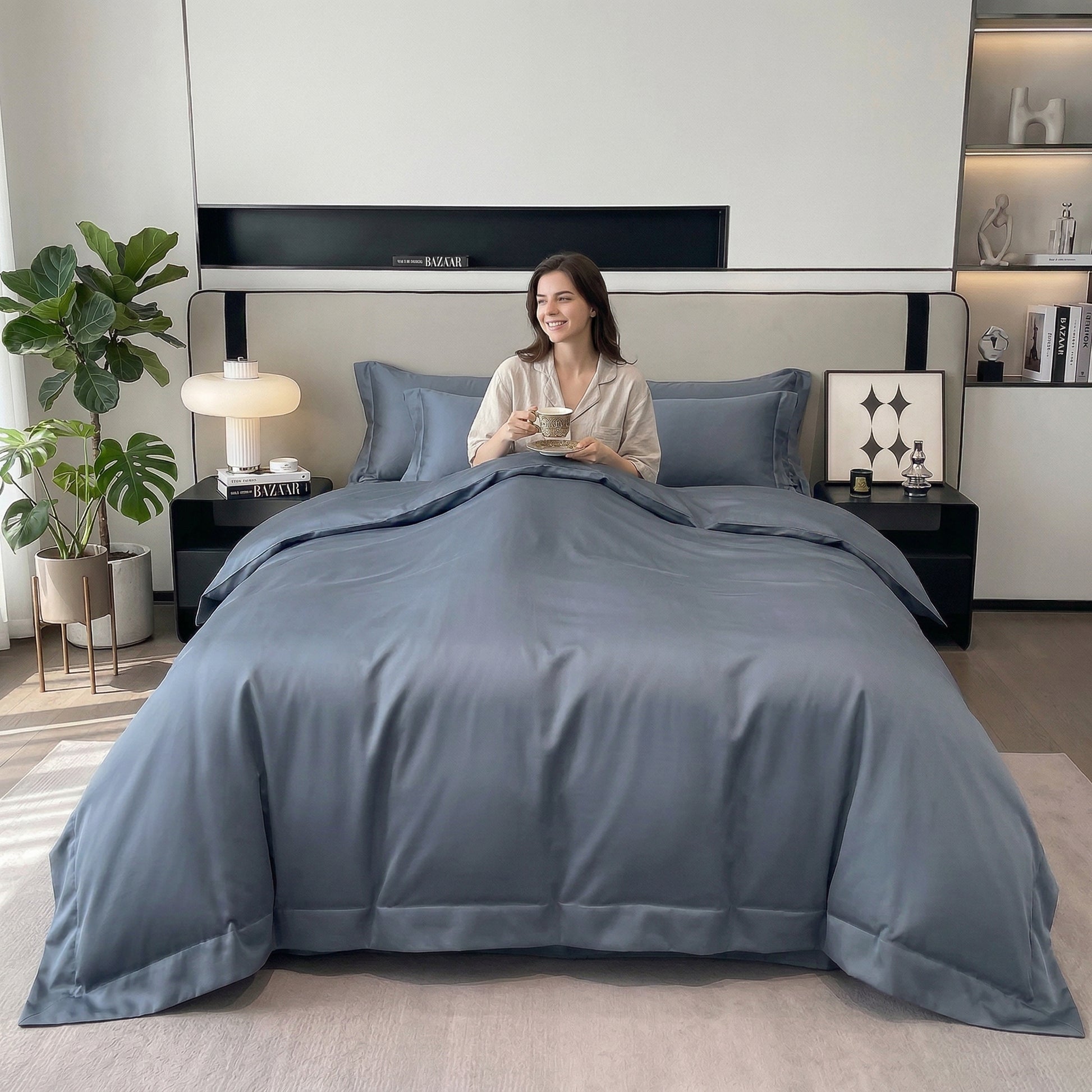 Smiling woman in a modern bedroom, sitting on a bed with a soft, solid blue cotton duvet cover set.