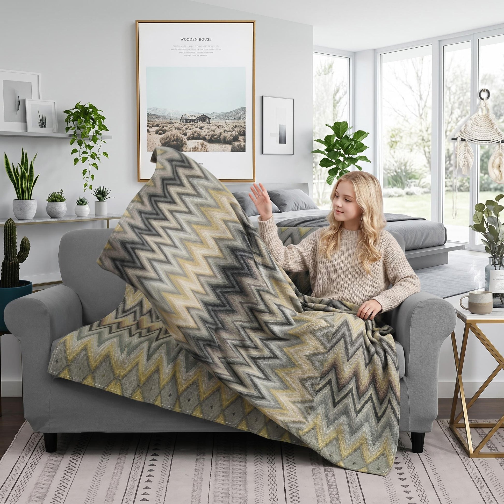 Woman on a gray sofa holding a Solstice Zig Geometric Throw Blanket with a multicolor zigzag pattern.