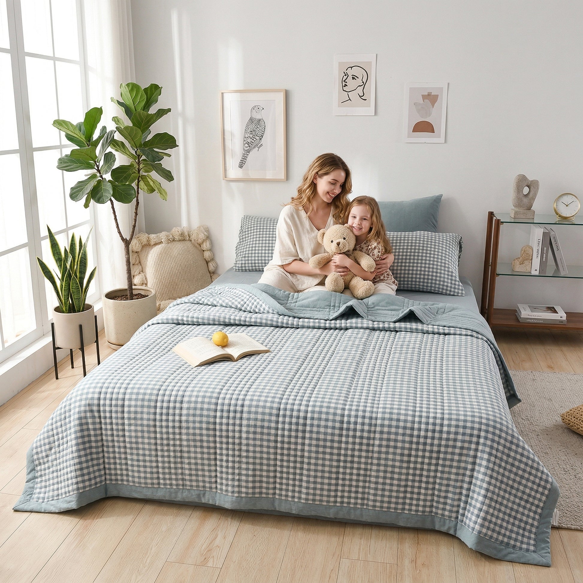Woman and child on a bed with a light blue and white checkered Summer Breeze Lightweight Blanket.