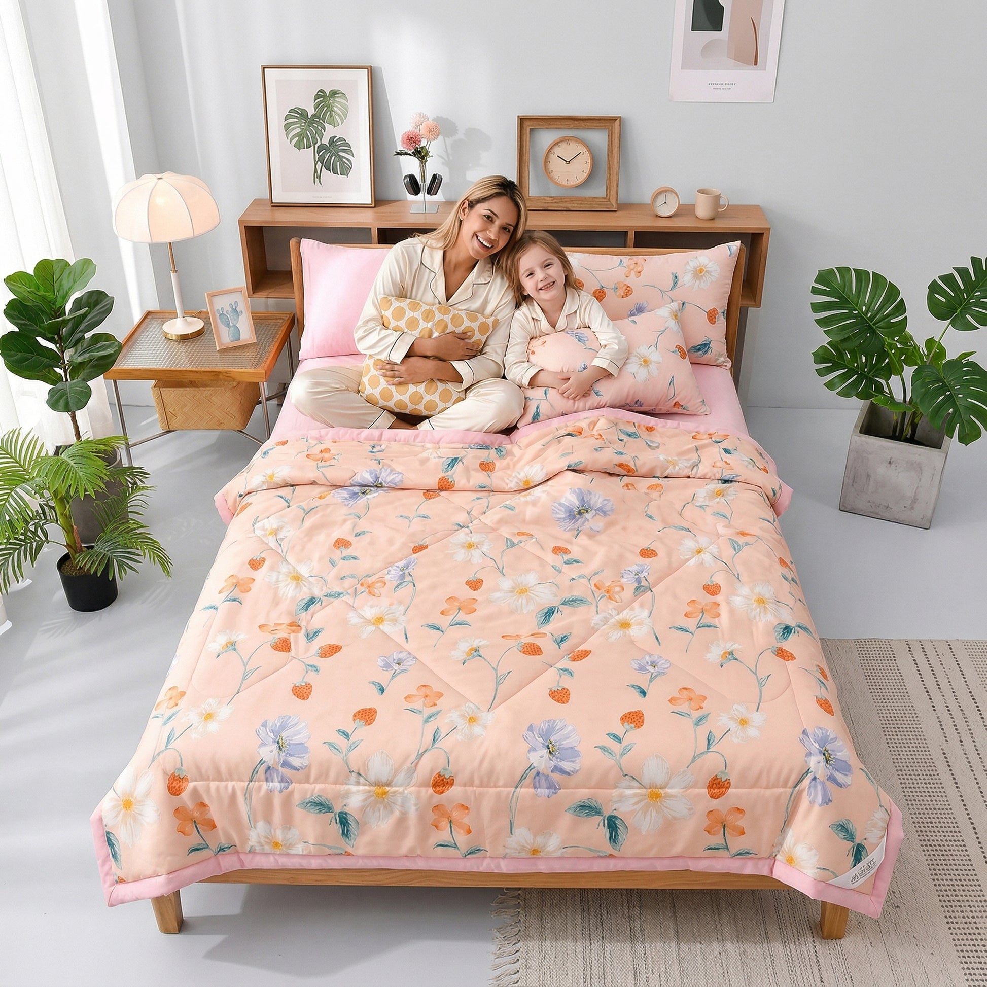 A mother and child smiling on a bed with a peach floral Summer Breeze lightweight microfiber blanket.