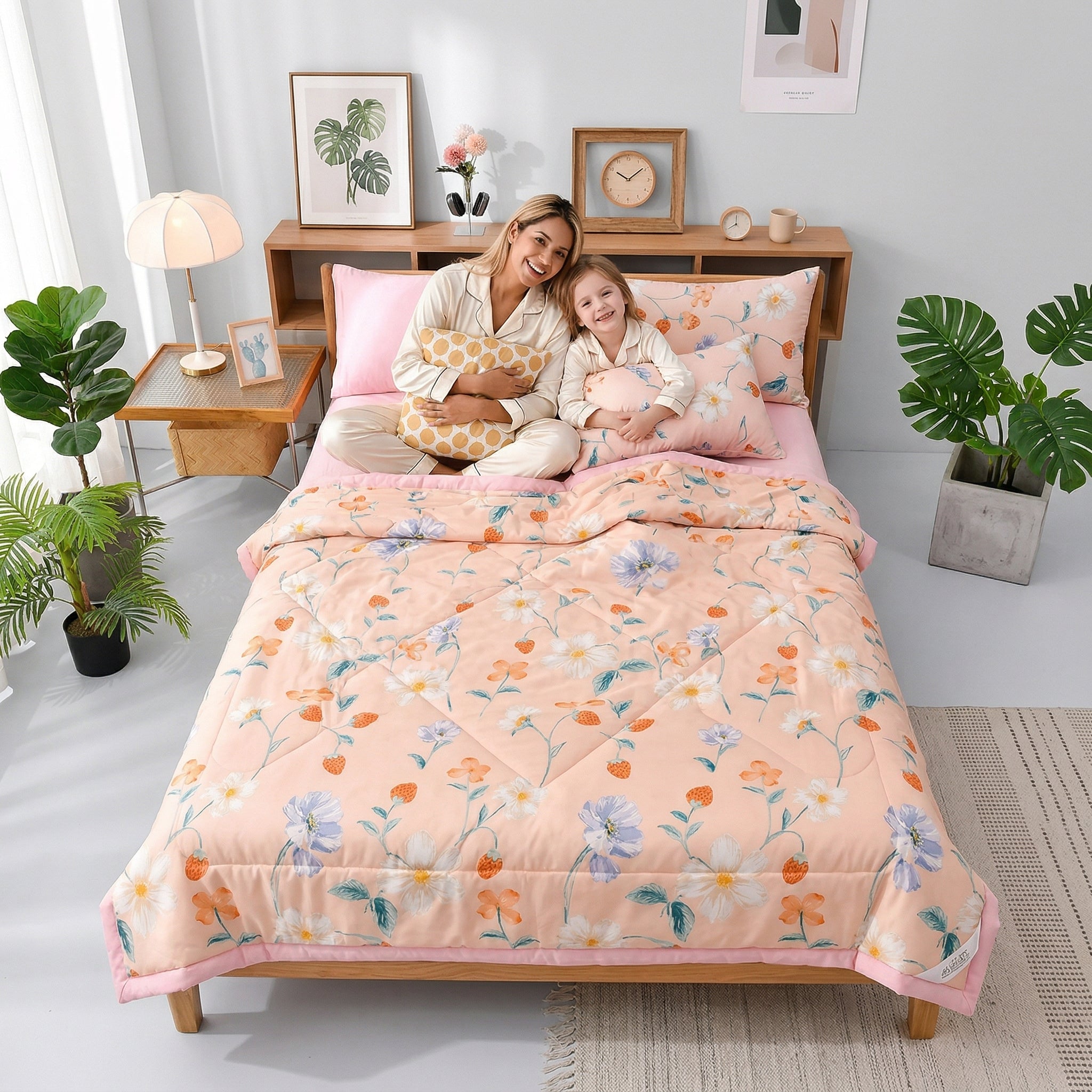 A mother and child smiling on a bed with a peach floral Summer Breeze lightweight microfiber blanket.