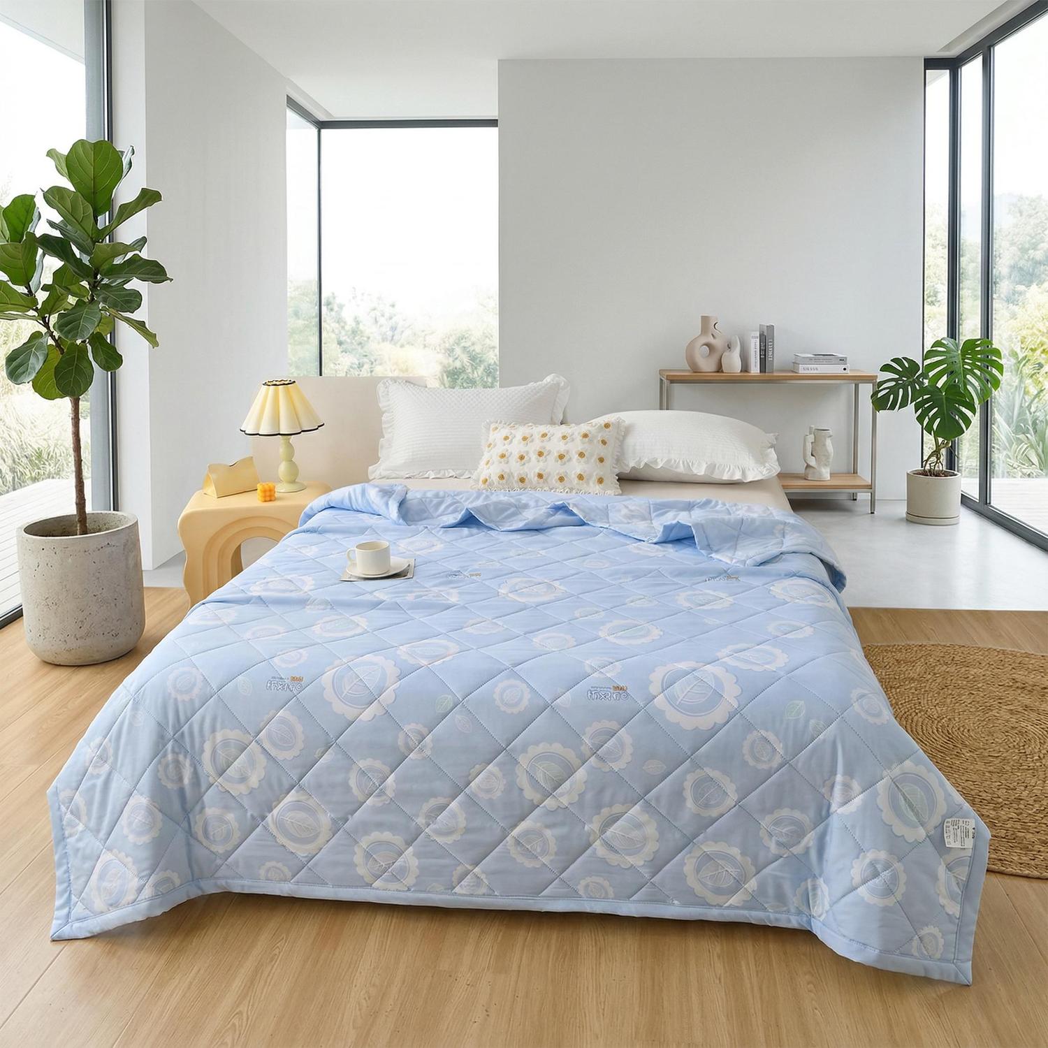 Light blue ultrasonic quilted summer comforter with a subtle floral pattern on a bed in a bright room.