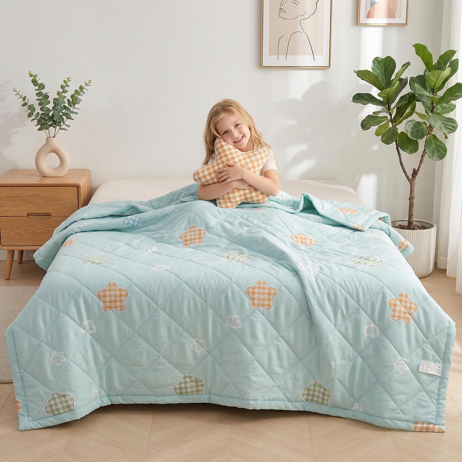 Smiling child on a bed with a light blue ultrasonic quilted comforter featuring colorful plaid star patterns.