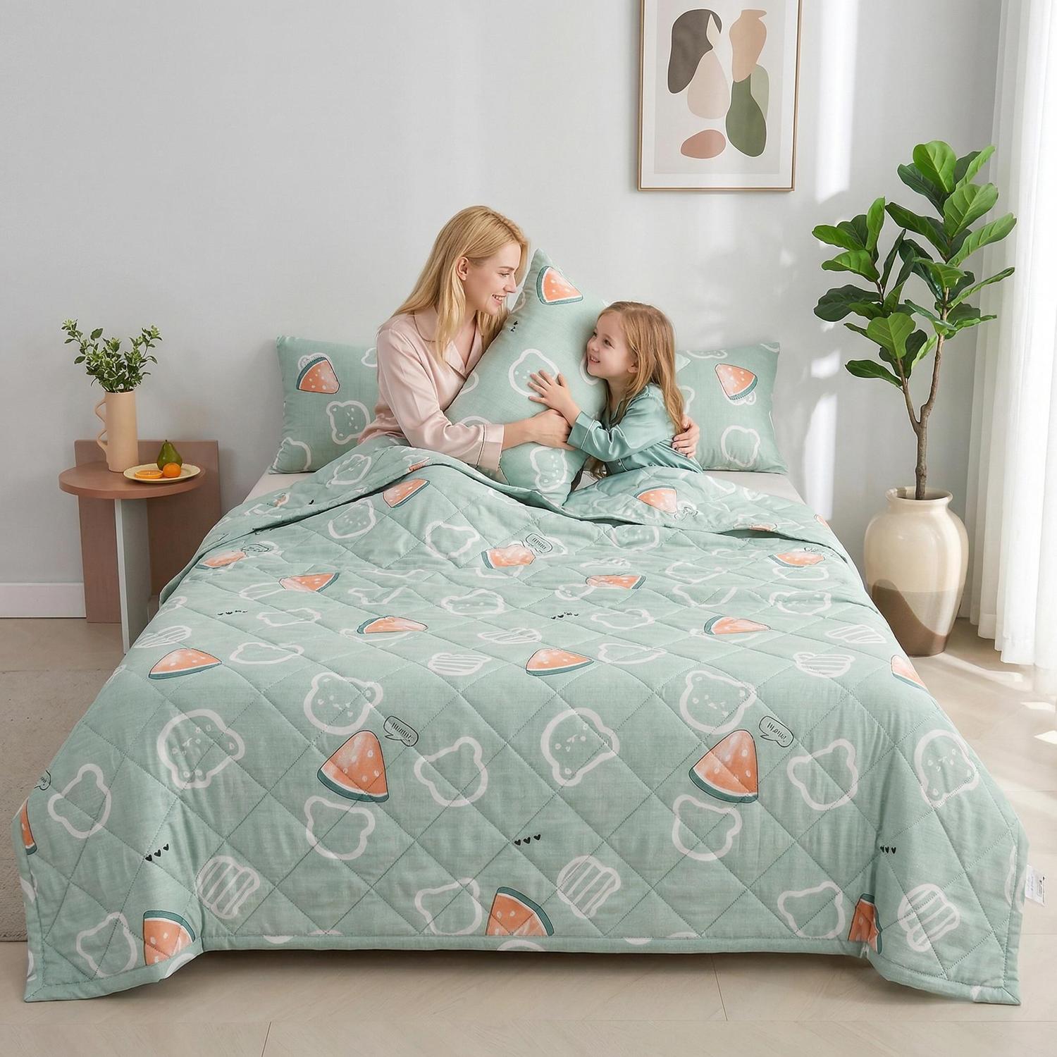Light green summer comforter with playful bear and watermelon patterns on a bed with a mother and child.