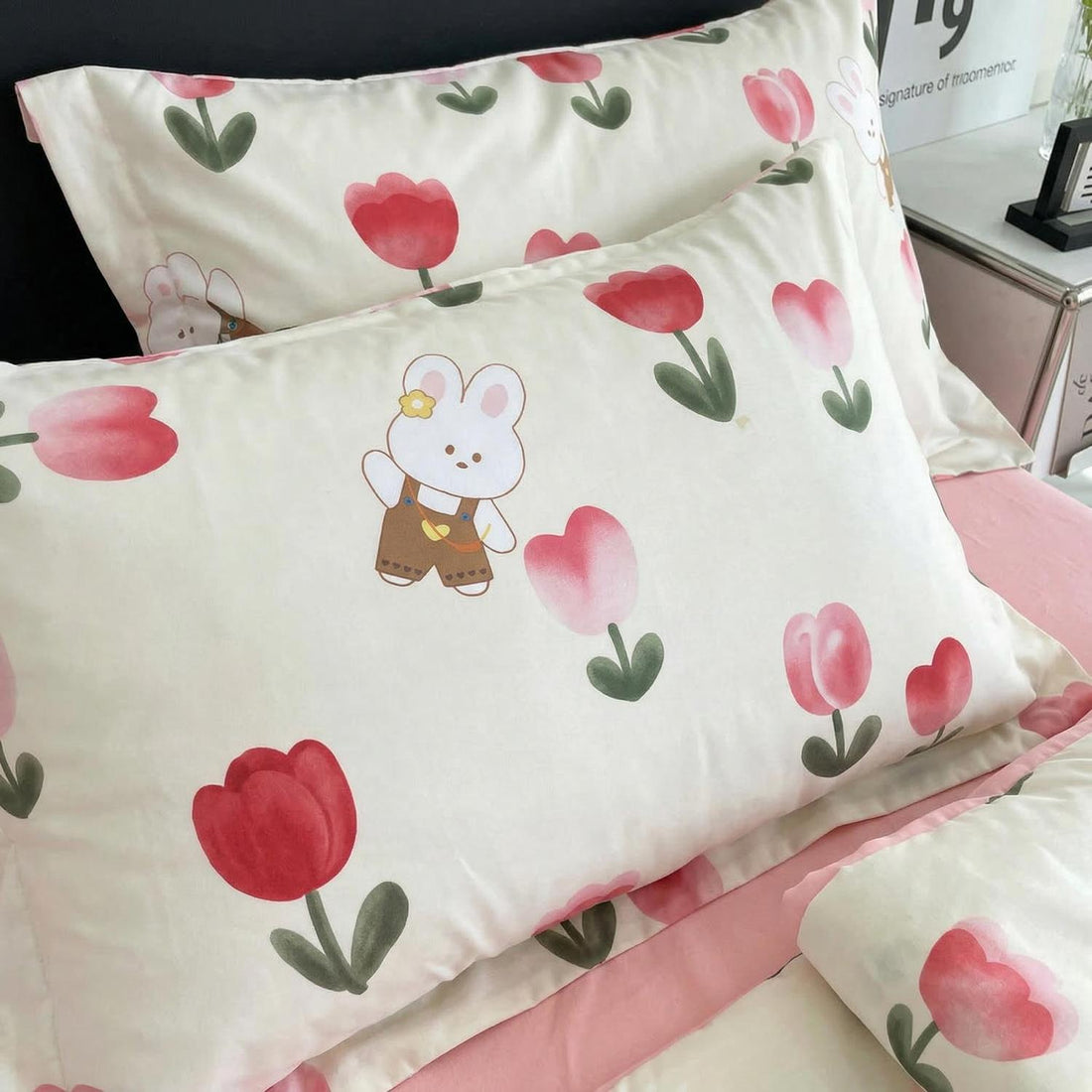 Mother and child on a bed with a white ice silk quilt featuring pink tulip patterns and a bunny.