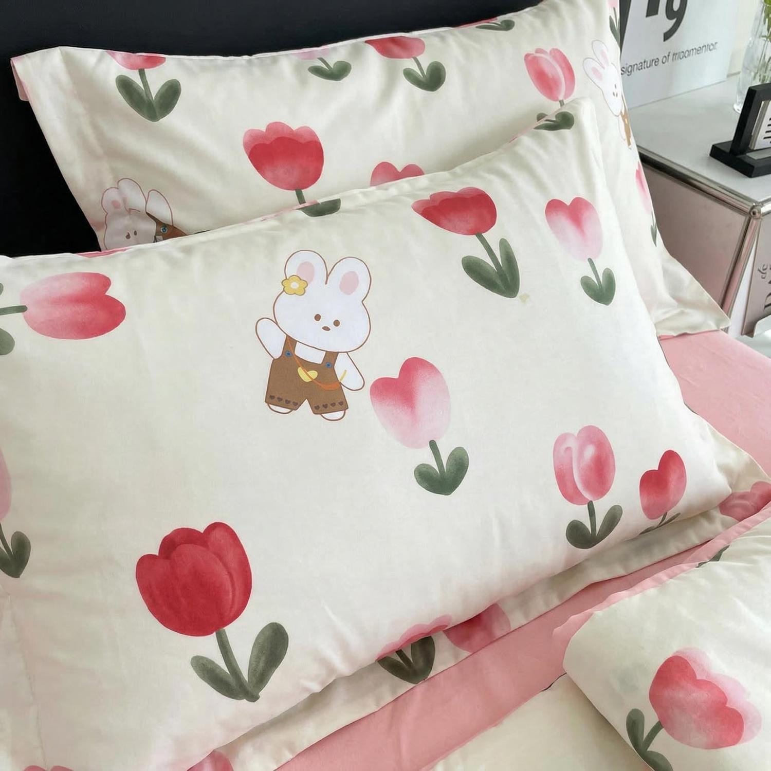 White ice silk pillowcases with a cute bunny and pink tulip pattern, on a pink sheet.