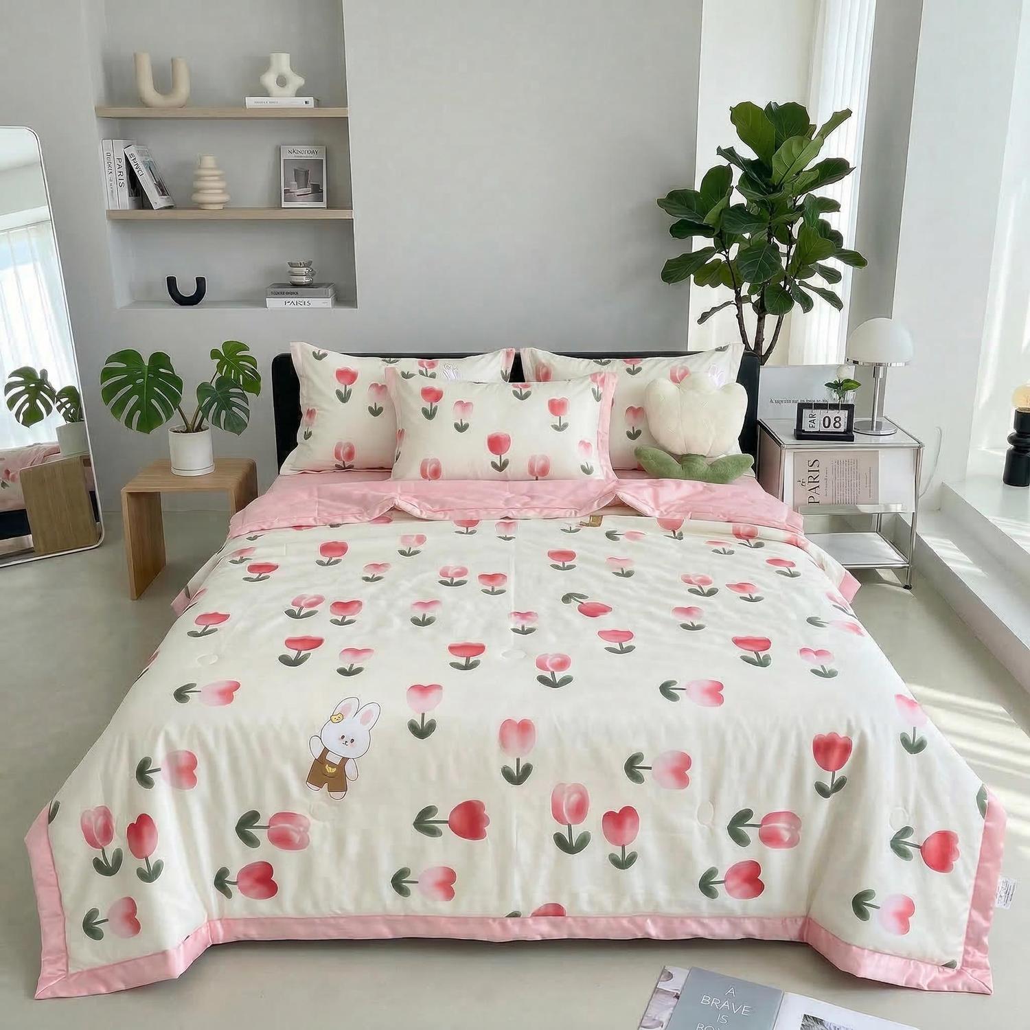 White ice silk quilt set with pink tulip and bunny print, on a bed in a bright room.