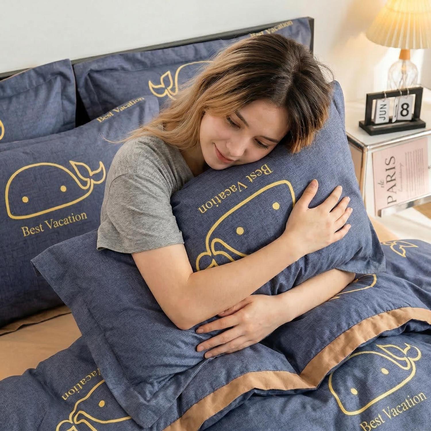 Woman hugging a blue "Best Vacation" whale print pillow from the Summer Cool Ice Silk Quilt Set.