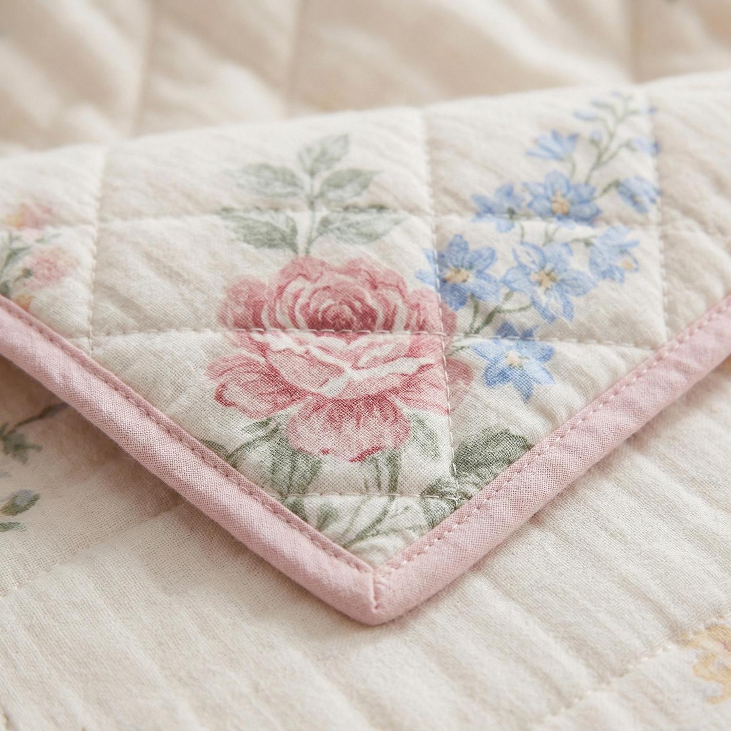Close-up of a Summer Inspired Quilt Bedding Set, featuring a quilted pink floral pattern with blue flowers.