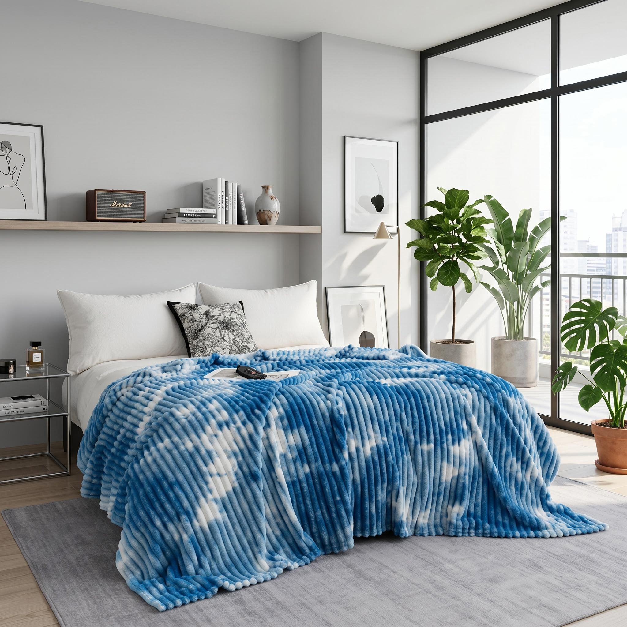 Blue and white tie-dye flannel fleece blanket draped on a bed in a modern bedroom.