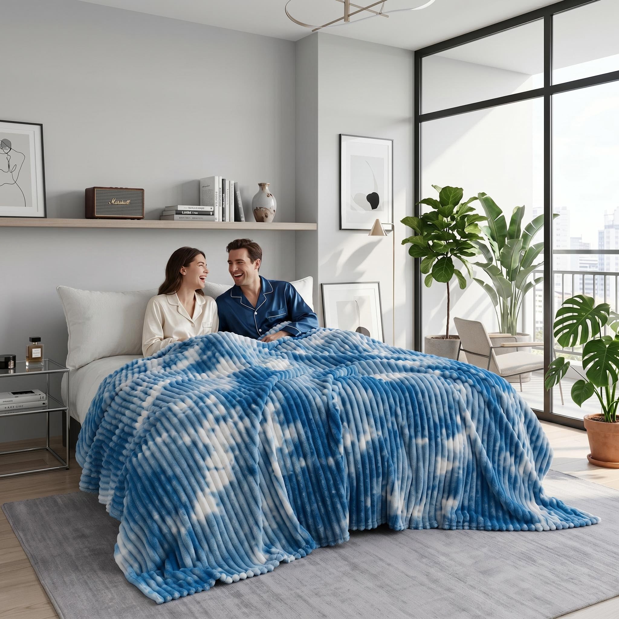 Blue and white tie-dye flannel fleece blanket draped over a bed with a smiling couple.