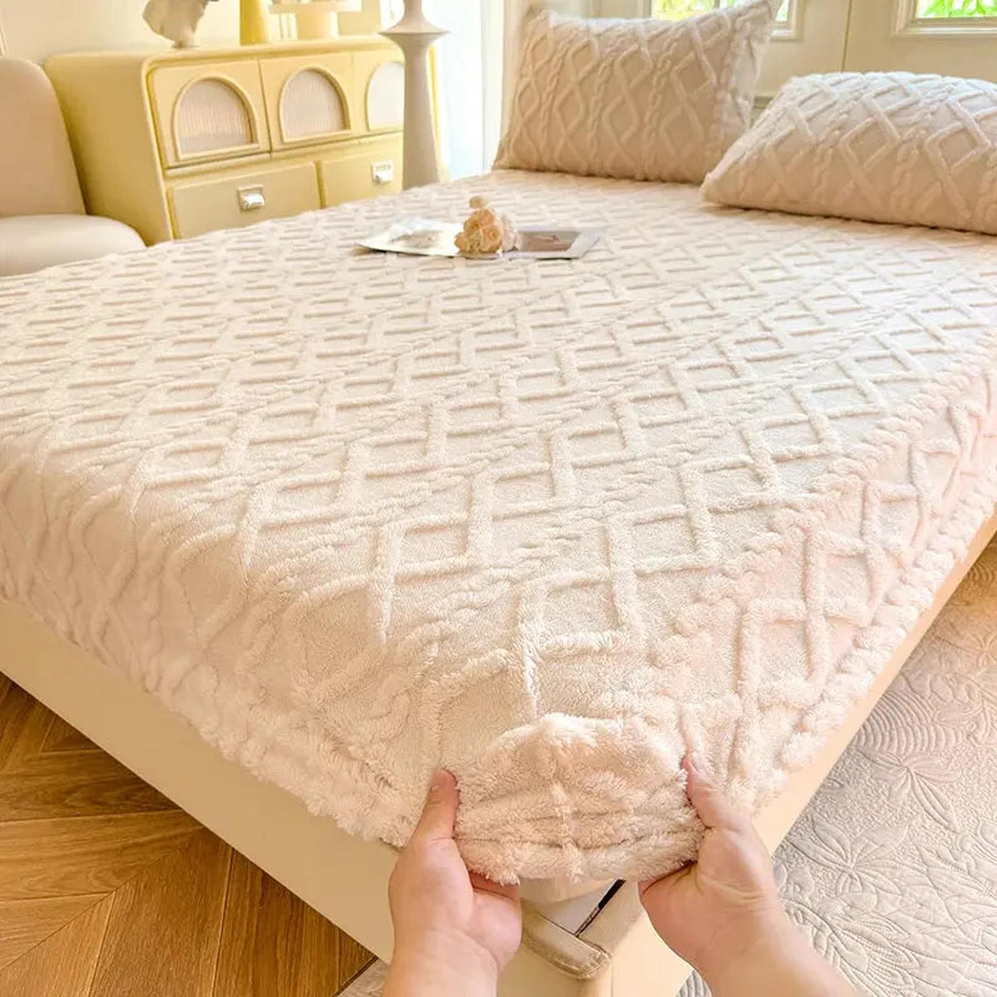 Cream coral fleece fitted bed sheet with a textured ribbed diamond pattern, shown being stretched onto a mattress.