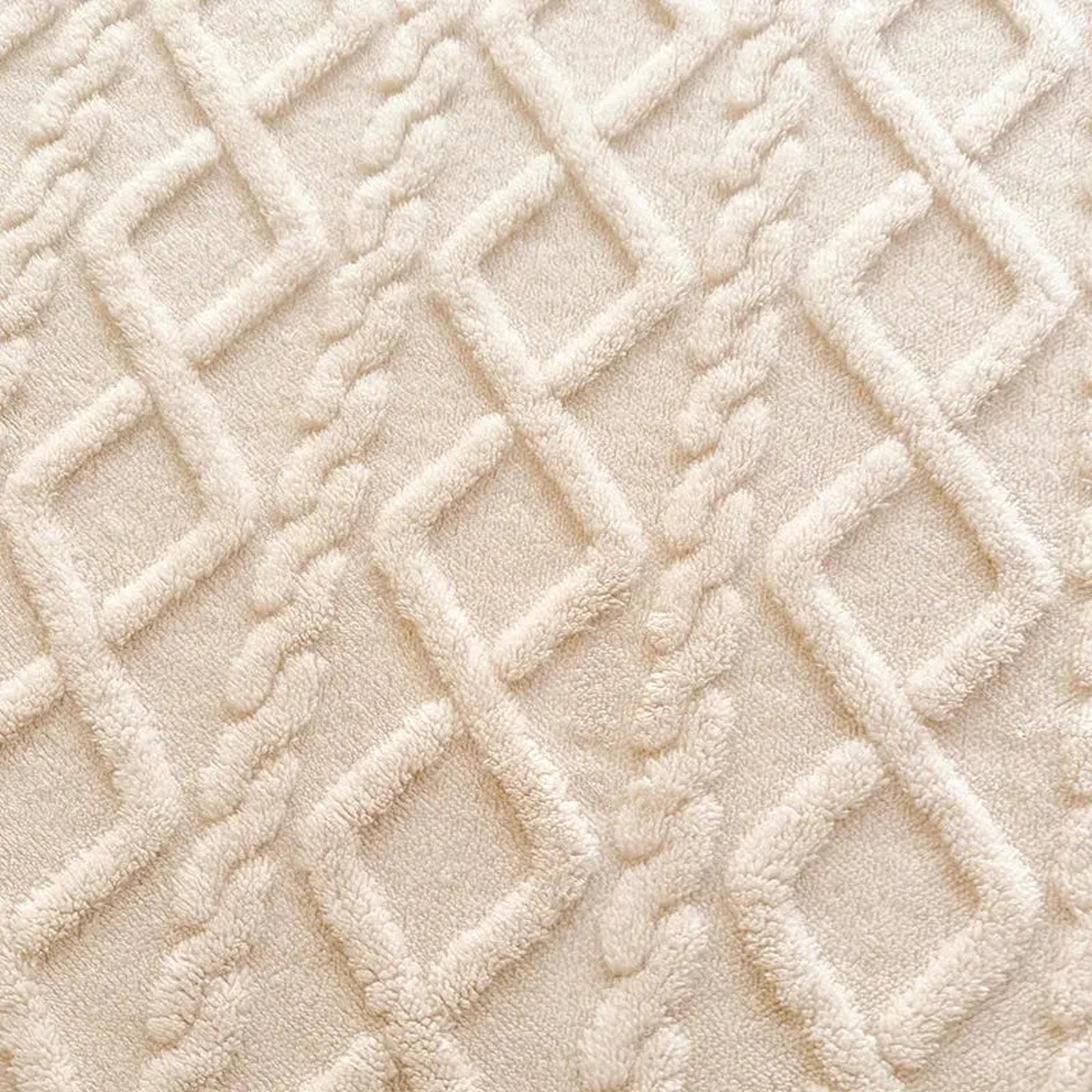 Close-up of a cream coral fleece fitted bed sheet with a textured ribbed diamond pattern.