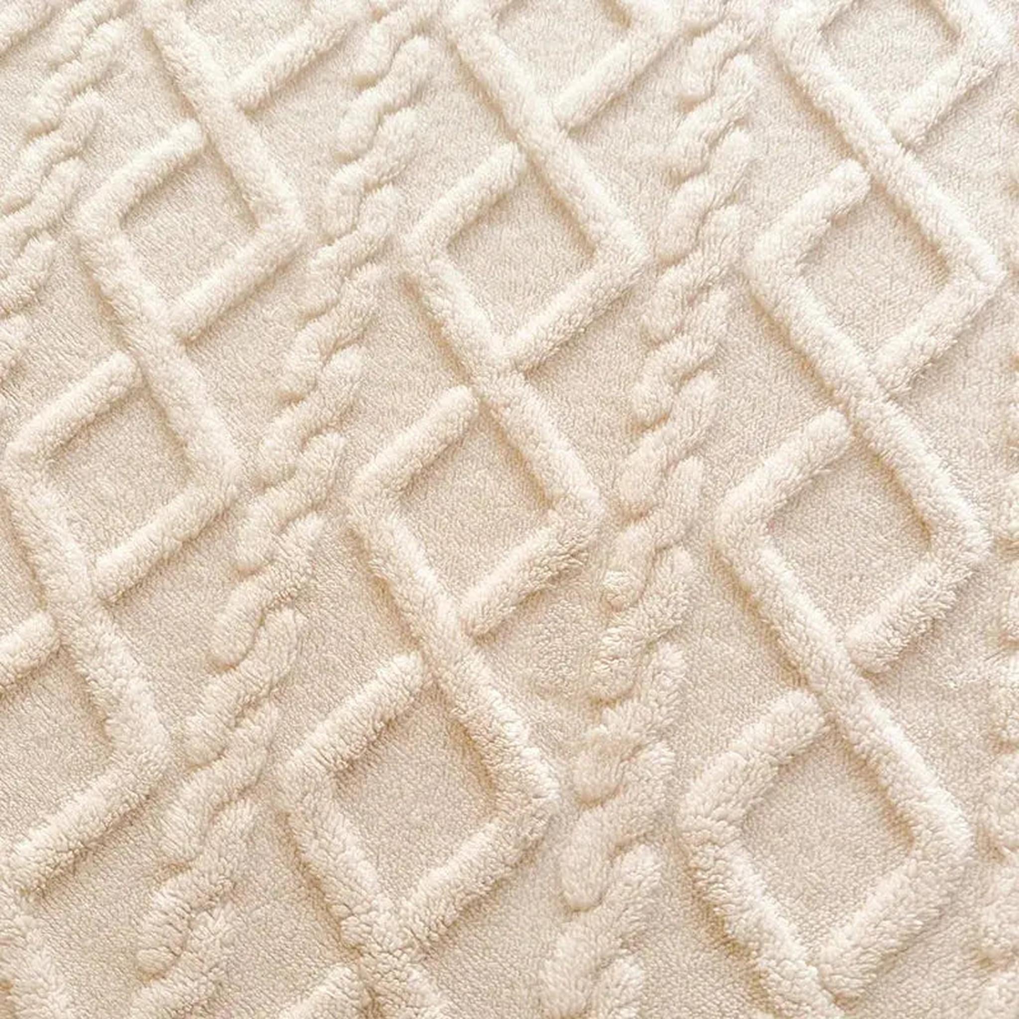 Close-up of a cream coral fleece fitted bed sheet with a textured ribbed diamond pattern.