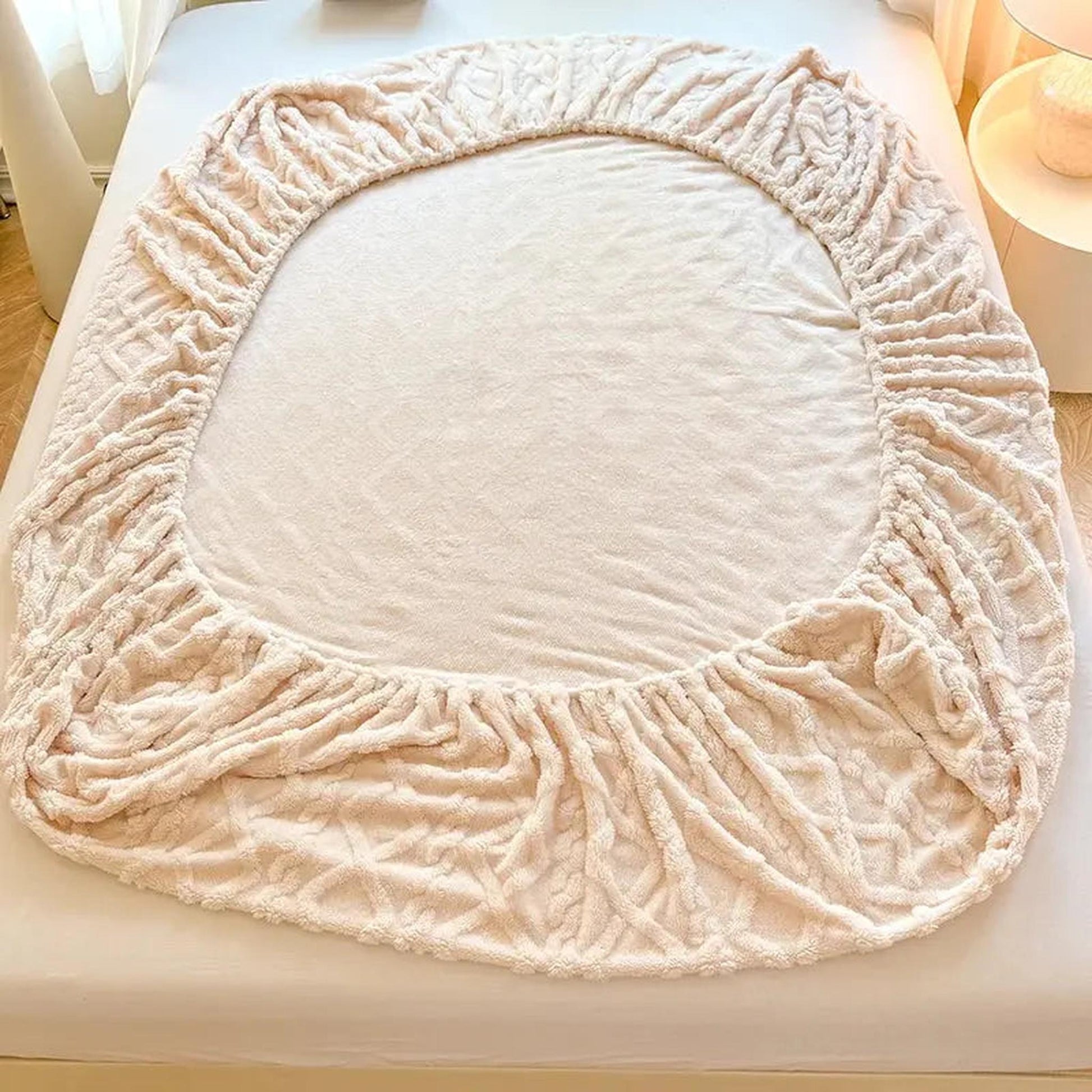 Light pink coral fleece fitted bed sheet with textured ribbed fabric and elasticized edges.