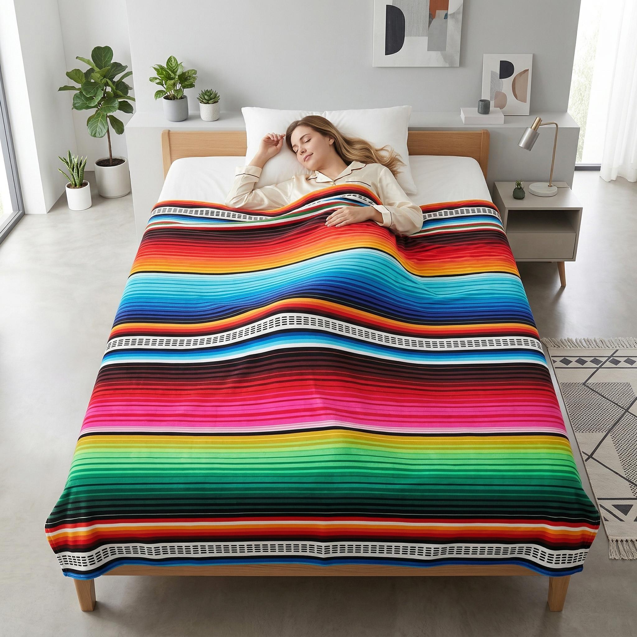 Woman sleeping soundly under a vibrant, multicolor striped flannel blanket on a light wood bed.