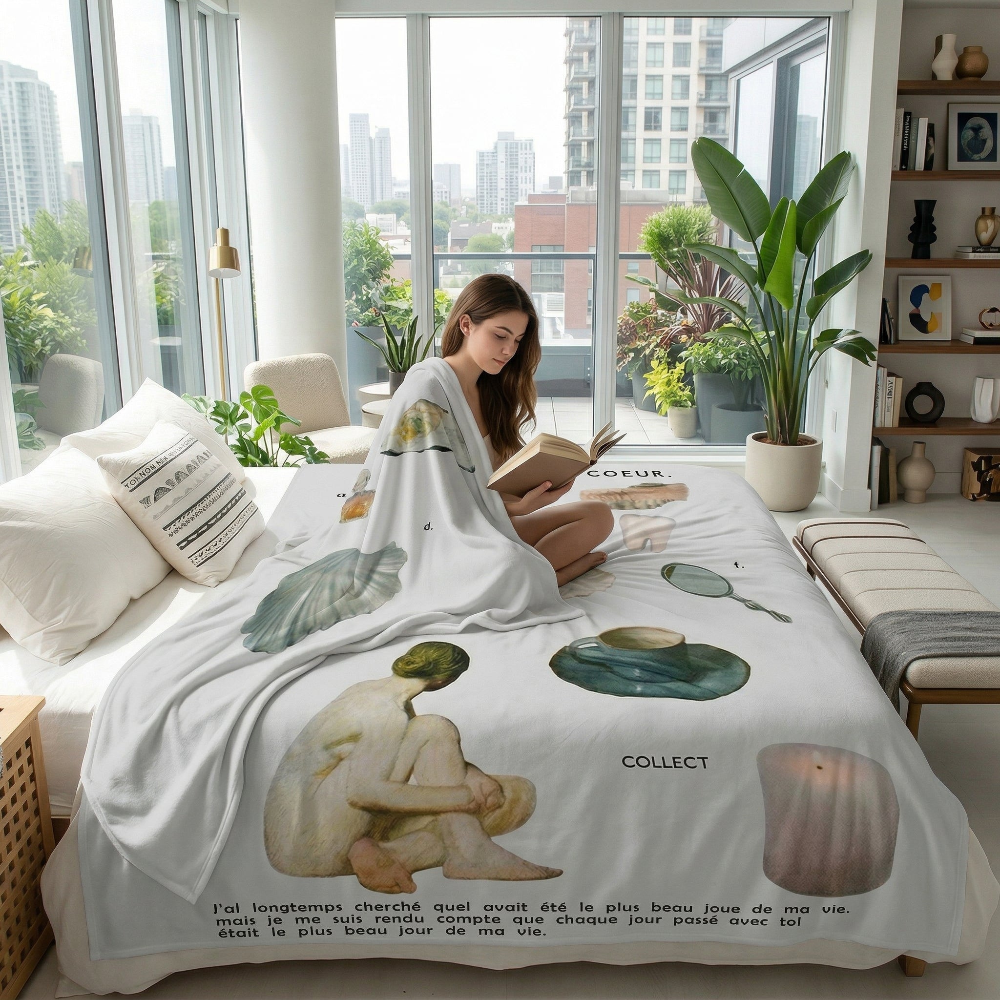 Woman reading in bed, covered by a white Vikama flannel blanket with artistic nude figures and French text.