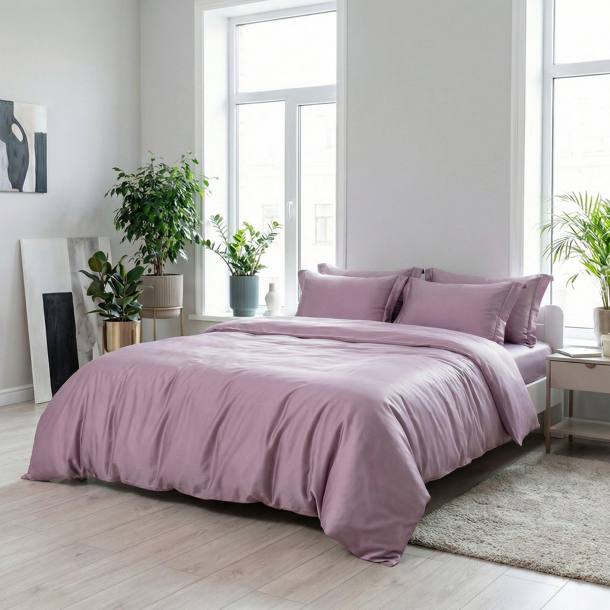Muted violet minimalist silk bedding set with a satin finish on a bed in a bright room.