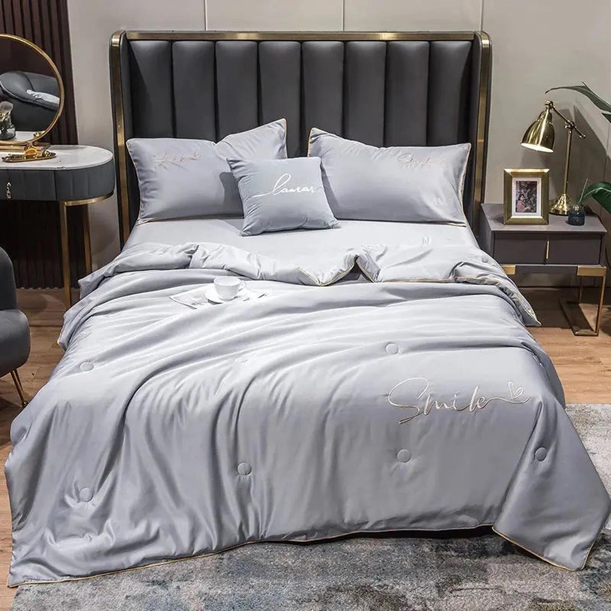 Light gray washed silk summer quilt set with embroidered "Smile" and "Love" details on a modern bed.