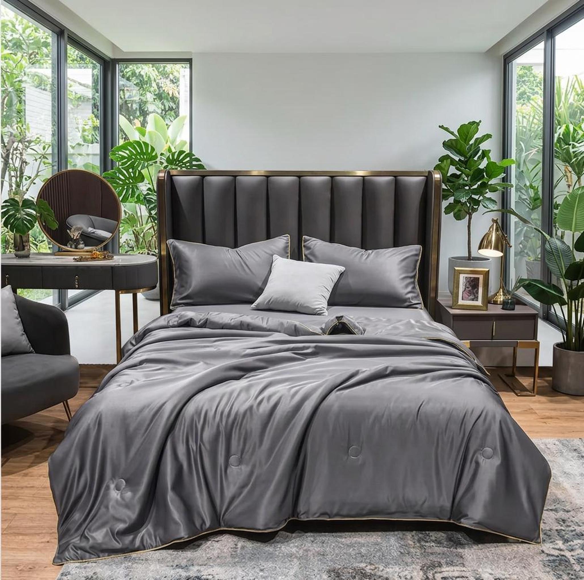 Gray washed silk summer quilt set with subtle embroidery on a bed in a modern bedroom.