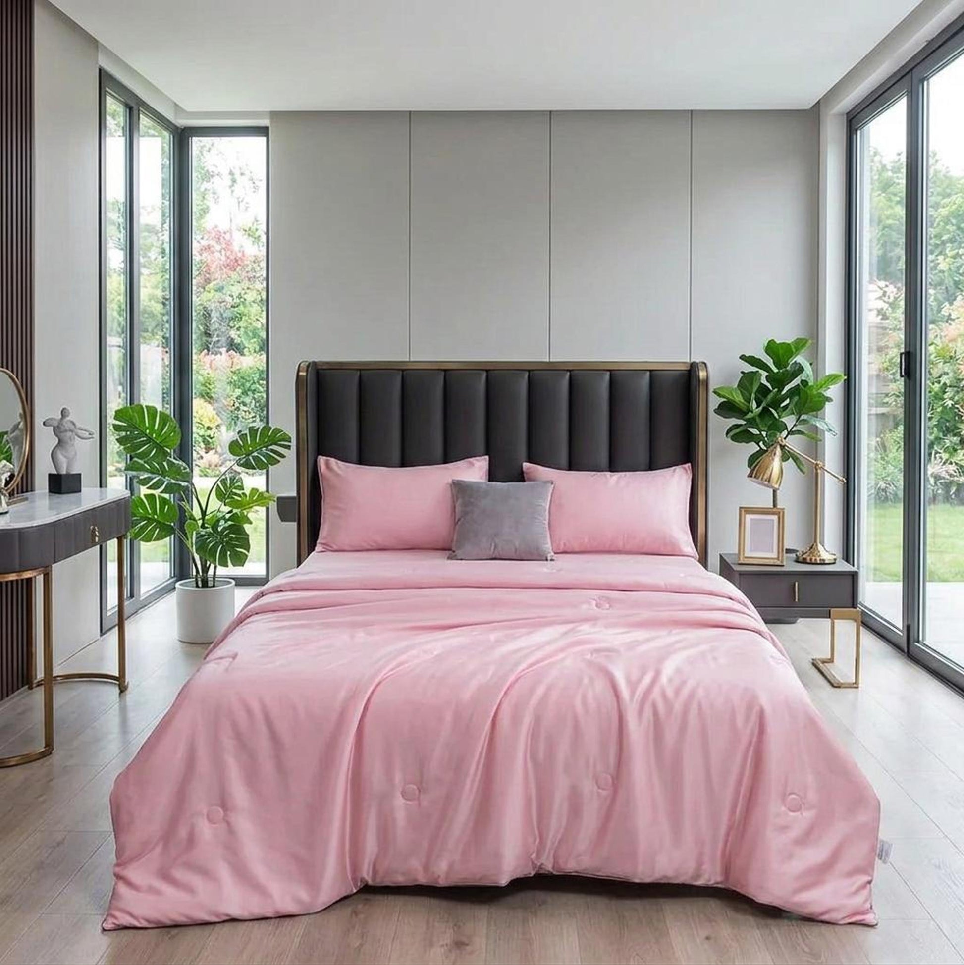 Pink washed silk summer quilt set with embroidered finish on a bed in a modern bedroom.