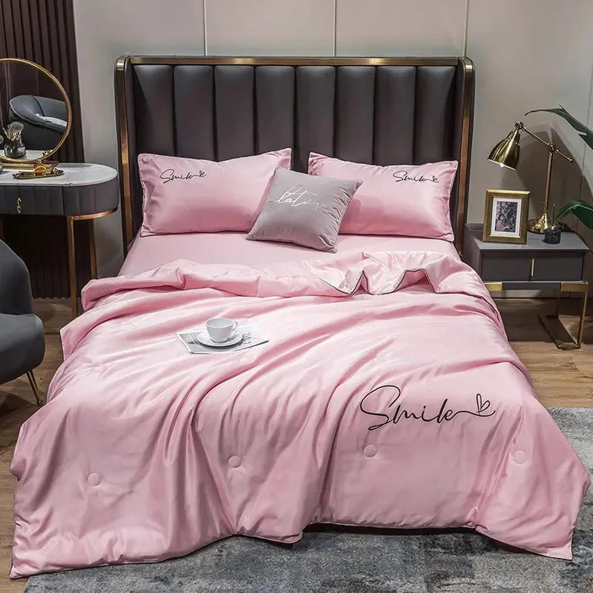 Pink washed silk summer quilt set with "Smile" embroidery, two pillowcases, and a decorative throw pillow.