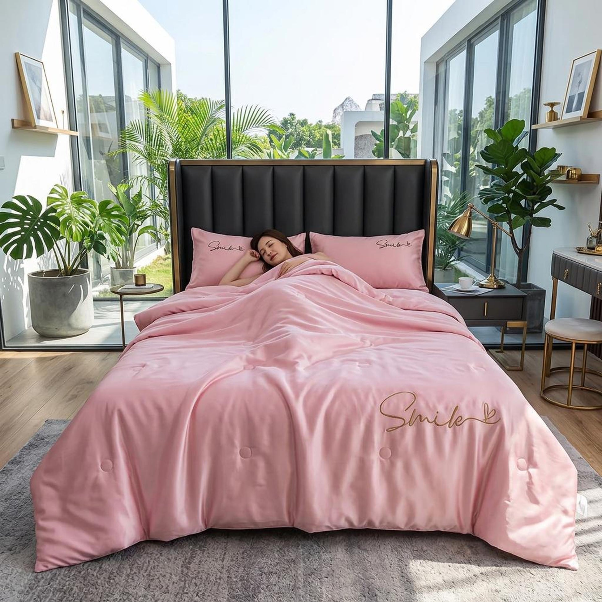 Pink washed silk summer quilt set with "Smile" embroidery on a bed in a bright room.