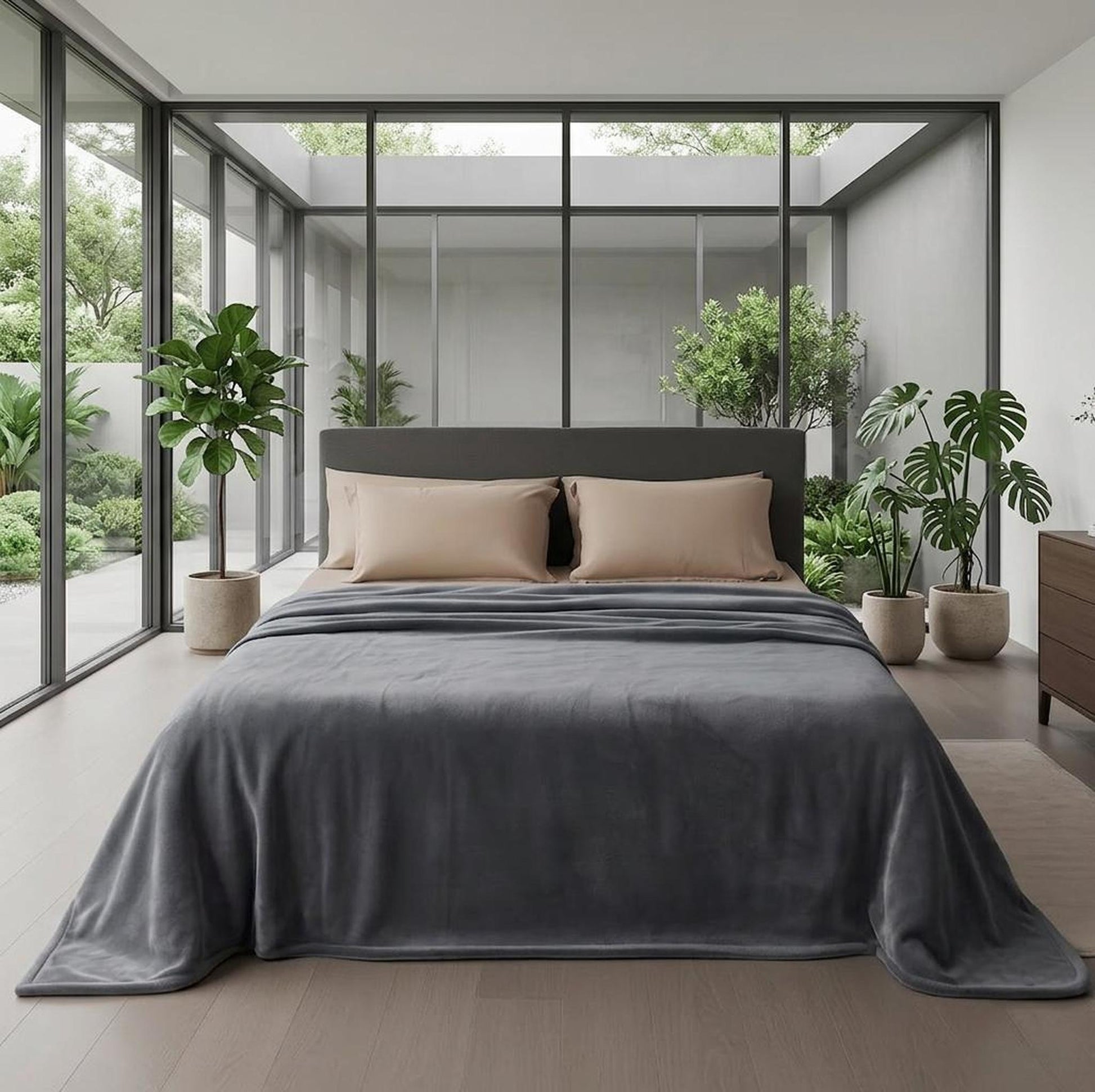 Reversible dark moon grey flannel fleece blanket draped on a bed in a modern bedroom.