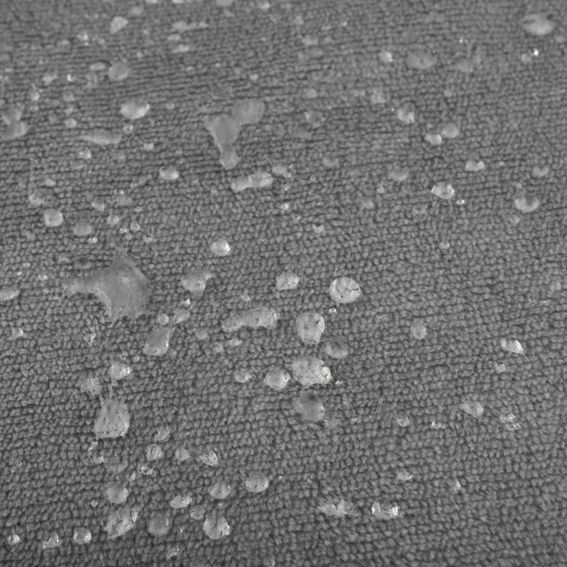 Close-up of a dark moon grey waterproof flannel fleece blanket with water beads on its surface.