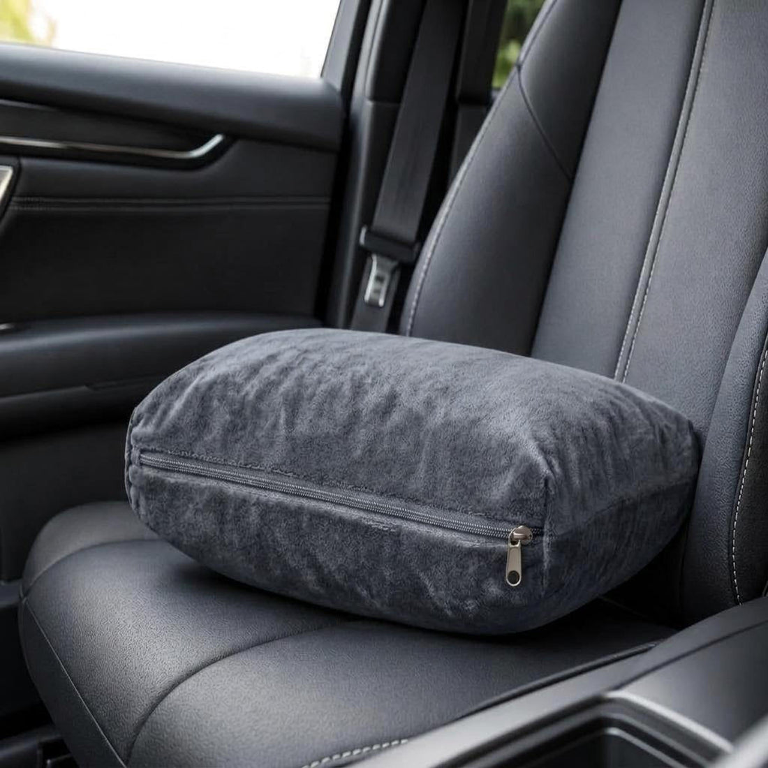 Woman sleeping in an airplane seat wrapped in a soft, charcoal gray Wayfarer travel blanket.