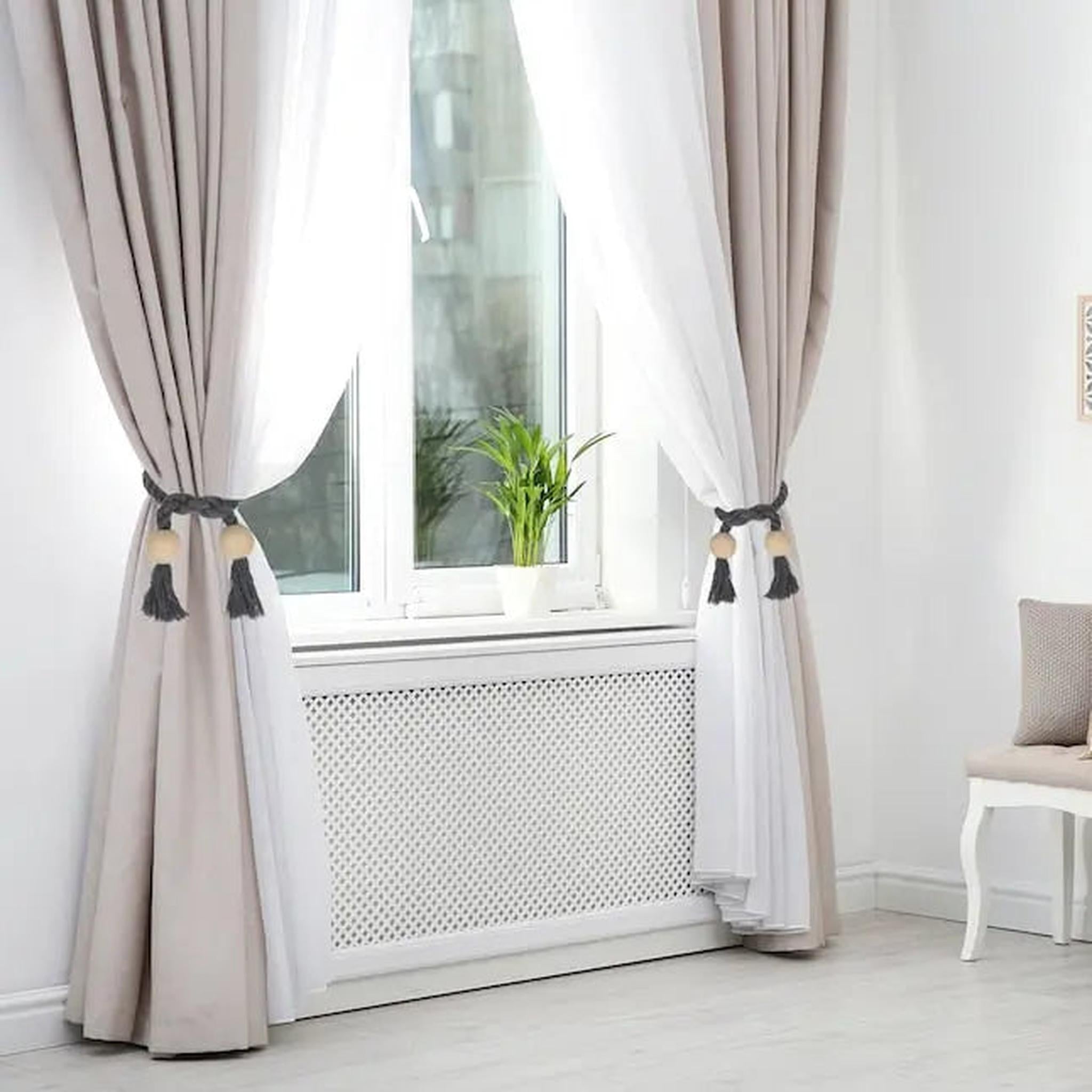 Grey braided magnetic curtain tiebacks with wooden beads and tassels holding back beige and white curtains.